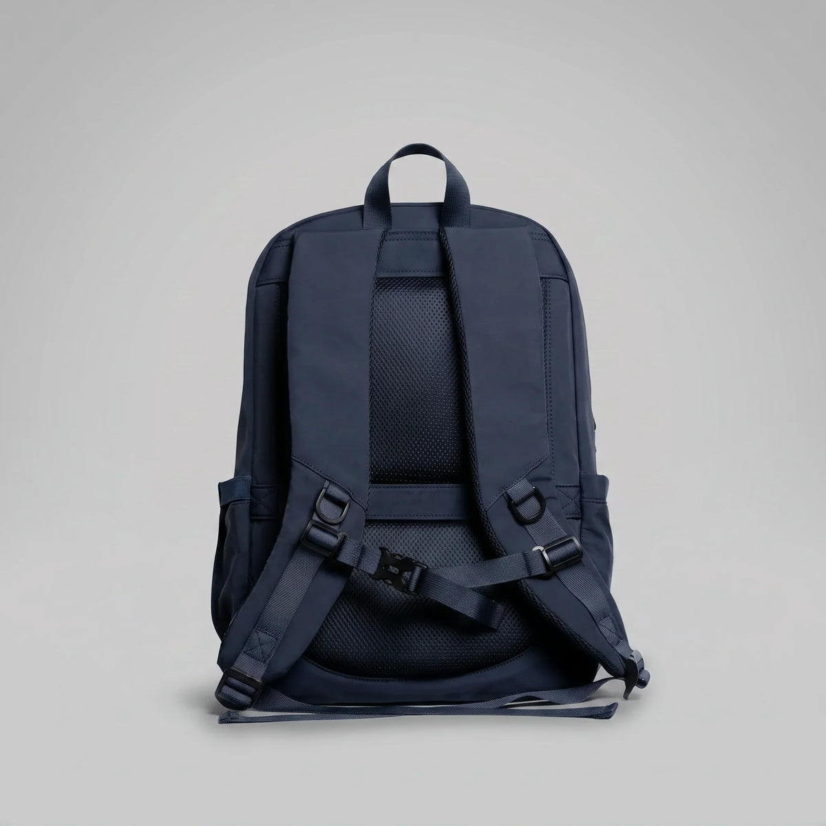 The back panel and padded shoulder straps of a hybeks Drift Backpack in Midnight Transit, the harness that carries a laptop on a two-wheeler commute
