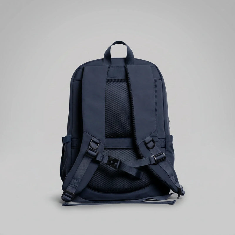 The back panel and padded shoulder straps of a hybeks Drift Backpack in Midnight Transit, the harness that carries a laptop on a two-wheeler commute