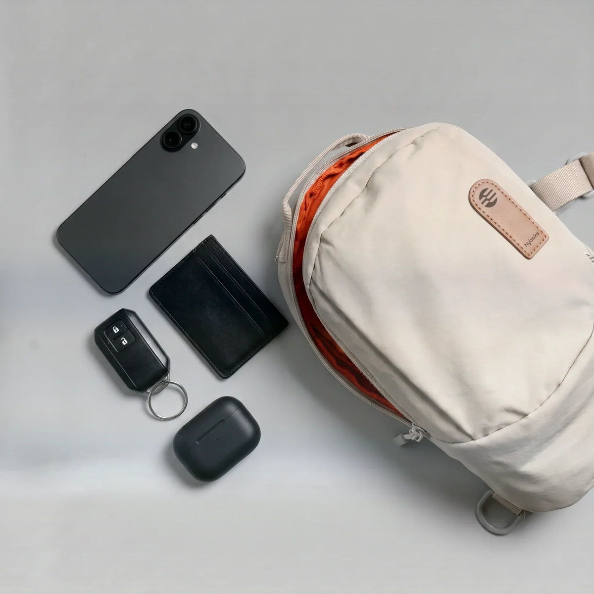 A packed hybeks Drift Sling in Morning Fog seen from above, holding the essentials that travel as a personal item