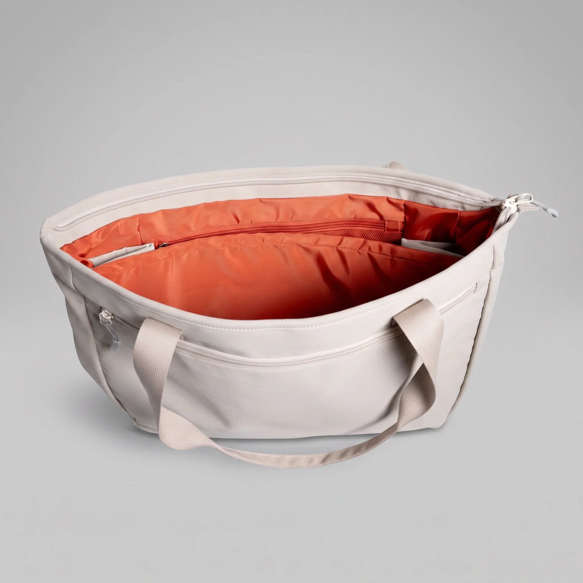 The open main compartment of a hybeks Drift Tote in Morning Fog, the two-compartment layout that lets a laptop lift straight out at airport security