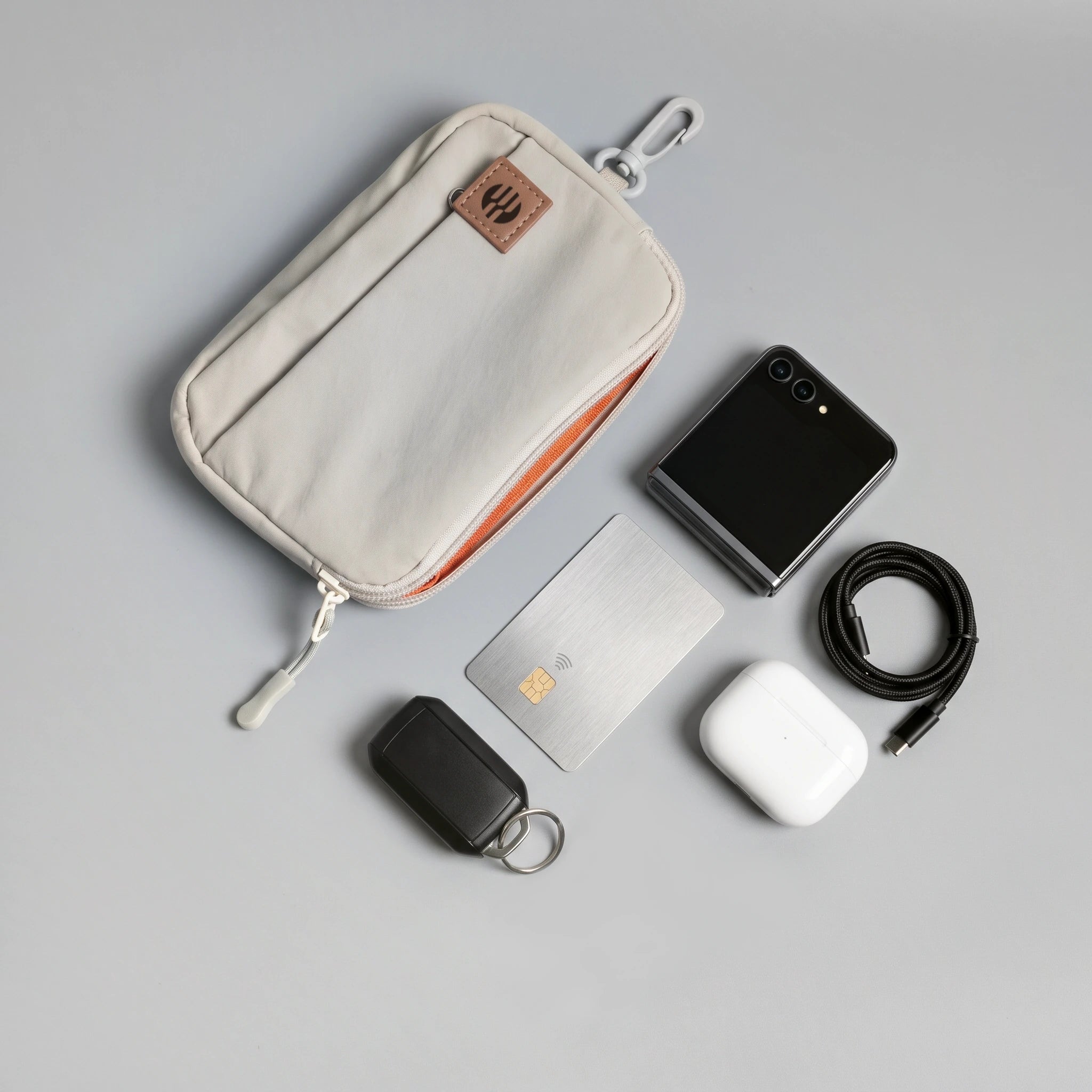 hybeks Drift Kit in Morning Fog, flat lay with the earbuds, cable, card, phone and key tracker it holds.